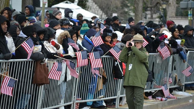 Ranger taking a picture while standing next to a large event crowd